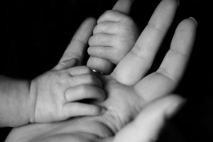 a mother and child's hands photographed in B&W