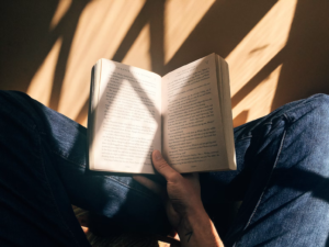 a person reading a book bathed in sunlight